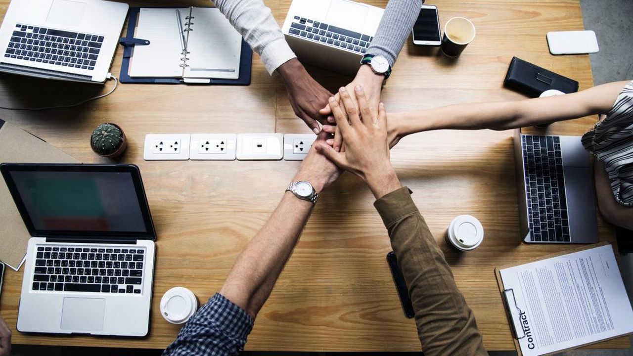 Business team joining hands over a desk